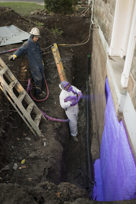 A worker applying waterproofing membrane
